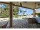 Outdoor kitchen under a covered patio with a grill, mini-fridge, and view of the pool and landscaping at 17905 Machair Ln, Land O Lakes, FL 34638