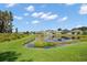 Community pond surrounded by well-maintained lawns and beautiful landscaping in a serene neighborhood setting at 17905 Machair Ln, Land O Lakes, FL 34638