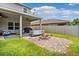 Charming backyard with a covered patio, an outdoor fire pit, and manicured lawn at 18566 Hunters Meadow Walk, Land O Lakes, FL 34638