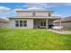 Expansive backyard featuring a covered patio, fire pit, and lush green lawn at 18566 Hunters Meadow Walk, Land O Lakes, FL 34638