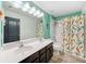 Bathroom featuring a double sink vanity, a shower-tub combo with a colorful mermaid-themed shower curtain at 18566 Hunters Meadow Walk, Land O Lakes, FL 34638