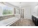 Bright bathroom features a soaking tub with tile surround and a separate glass enclosed shower at 18566 Hunters Meadow Walk, Land O Lakes, FL 34638