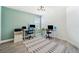 Bright bedroom featuring grey wood-look floors, a modern ceiling light, and two work-from-home desks at 18566 Hunters Meadow Walk, Land O Lakes, FL 34638