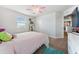 Cozy bedroom featuring carpet flooring, a ceiling fan, and a storage shelf with decorative plants at 18566 Hunters Meadow Walk, Land O Lakes, FL 34638
