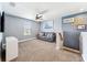 Cozy bonus room with gray sofa, carpet, ceiling fan, and bright natural lighting at 18566 Hunters Meadow Walk, Land O Lakes, FL 34638
