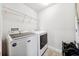 Efficient laundry room with modern washer and dryer, shelving, and convenient laundry organization at 18566 Hunters Meadow Walk, Land O Lakes, FL 34638