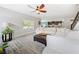 Bright living room showcasing a large sectional couch, ceiling fan, and view into the kitchen at 18566 Hunters Meadow Walk, Land O Lakes, FL 34638