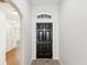 Inviting entryway with a black front door, sidelight, and light-colored walls at 18916 New Passage Blvd, Land O Lakes, FL 34638