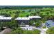 Elevated view showing the community building nestled among trees and a manicured golf course with lakes at 1934 Golfview Dr # 1934, Tarpon Springs, FL 34689