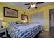 This bright bedroom has a full closet, decorative wall art, and neutral flooring with an overhead ceiling fan at 1934 Golfview Dr # 1934, Tarpon Springs, FL 34689