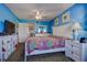 This cozy bedroom features blue walls, a ceiling fan, a TV and a connecting hallway to other rooms at 1934 Golfview Dr # 1934, Tarpon Springs, FL 34689