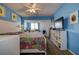 Bright bedroom with blue walls, built-in office, ceiling fan, and comfortable bed for a relaxing atmosphere at 1934 Golfview Dr # 1934, Tarpon Springs, FL 34689
