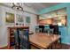 Inviting dining area features a wooden table set, decorative wine rack and colorful wall art adjacent to kitchen pass through at 1934 Golfview Dr # 1934, Tarpon Springs, FL 34689