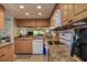 Well-lit kitchen featuring appliances, wood cabinets, and granite countertops at 1934 Golfview Dr # 1934, Tarpon Springs, FL 34689