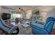Spacious living room with plush seating, ceiling fan, and sliding glass doors leading to a private balcony overlooking the green space at 1934 Golfview Dr # 1934, Tarpon Springs, FL 34689