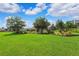 Manicured backyard with green lawn, mature trees, and a small gazebo, perfect for outdoor enjoyment and relaxation at 19531 Mossy Oak Ct, Brooksville, FL 34601