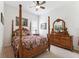 Primary bedroom with a four poster bed, dresser with mirror, neutral carpet, and natural light at 19531 Mossy Oak Ct, Brooksville, FL 34601