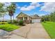 Inviting single-story home with lush landscaping, a well-manicured lawn, and a long driveway at 19531 Mossy Oak Ct, Brooksville, FL 34601