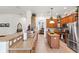 Bright kitchen with stainless steel appliances, wood cabinets, island, and tan granite countertops at 19531 Mossy Oak Ct, Brooksville, FL 34601