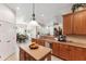 Bright open kitchen with wood cabinets, granite countertops, island, and stainless appliances at 19531 Mossy Oak Ct, Brooksville, FL 34601