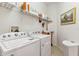 The laundry room showcases a washer and dryer with wire rack shelving above, offering ample storage space at 19531 Mossy Oak Ct, Brooksville, FL 34601
