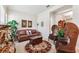 Cozy living room with a leather sofa, wicker chairs, and area rug, perfect for relaxation at 19531 Mossy Oak Ct, Brooksville, FL 34601