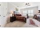 Primary bedroom featuring a ceiling fan, shutters, and a sitting area at 19531 Mossy Oak Ct, Brooksville, FL 34601