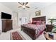 Primary bedroom with ceiling fan, shutters, and en-suite bathroom at 19531 Mossy Oak Ct, Brooksville, FL 34601