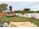 View of the backyard with a mix of grass, partial fence and covered storage at 2016 Woodward Ave, Dunedin, FL 34698