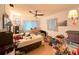 Bedroom with a ceiling fan, window with light curtains and cluttered bed and floor at 2016 Woodward Ave, Dunedin, FL 34698