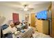 View of the bedroom, showcasing a ceiling fan, TV and furniture with cluttered bed and floor at 2016 Woodward Ave, Dunedin, FL 34698