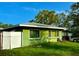 This single-story home is surrounded by greenery and has a fenced-in yard at 2016 Woodward Ave, Dunedin, FL 34698