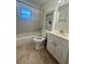 Clean bathroom with shower-tub combo, white vanity, built in shelves for storage and neutral tiling at 2234 Marietta Ave, Spring Hill, FL 34608