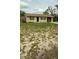A quaint single-story home with a simple facade, large front yard and a driveway leading to covered parking at 2234 Marietta Ave, Spring Hill, FL 34608