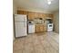 Efficient kitchen with wood cabinets, tile backsplash, white appliances and tile flooring at 2234 Marietta Ave, Spring Hill, FL 34608