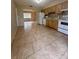 Efficient kitchen with wood cabinets, tile backsplash, white appliances, and tile flooring overlooking living area at 2234 Marietta Ave, Spring Hill, FL 34608