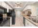 This kitchen offers sleek black appliances, granite countertops, and white cabinets for ample storage at 2310 Augusta Dr, Spring Hill, FL 34606