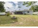 Spacious backyard featuring a well-kept lawn, a charming fire pit, and a screened-in porch at 27263 Warner Ave, Brooksville, FL 34602