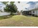 Large backyard featuring mature trees, a privacy fence, and a cozy fire pit perfect for gatherings at 27263 Warner Ave, Brooksville, FL 34602