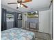 Bedroom with light gray walls, ceiling fan, and a wall-mounted television at 27263 Warner Ave, Brooksville, FL 34602