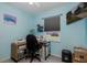 Comfortable, light blue bedroom features a sewing station and TV at 27263 Warner Ave, Brooksville, FL 34602