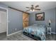Relaxing bedroom with a wooden sliding door, ceiling fan, and gray walls at 27263 Warner Ave, Brooksville, FL 34602