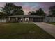 Charming single-story brick home at dusk with well-maintained lawn and covered garage at 27263 Warner Ave, Brooksville, FL 34602