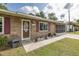 Close up of a single-story brick home with front door, shuttered windows, and screened in garage at 27263 Warner Ave, Brooksville, FL 34602