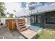 Backyard shot features a partially covered hot tub with stairs and wooden deck at 27263 Warner Ave, Brooksville, FL 34602
