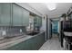 Modern kitchen with dual sink, gray countertops, green cabinets, and stainless steel appliances at 27263 Warner Ave, Brooksville, FL 34602