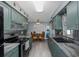 Bright kitchen with green cabinets, black appliances, gray countertops, and an adjacent dining area at 27263 Warner Ave, Brooksville, FL 34602
