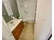 Bathroom with neutral tile, wood cabinets, and tub with shower at 300 Midwood Dr, Plant City, FL 33566