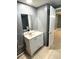 Bathroom featuring a white vanity, mirror, tiled floor, and partially open door at 300 Midwood Dr, Plant City, FL 33566
