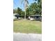 Charming single-story home with a well-maintained front yard, mature trees and chain link fence at 300 Midwood Dr, Plant City, FL 33566